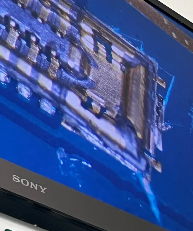 Imagine mărită a unui conector de pe placă, pe monitorul microscopului din atelier