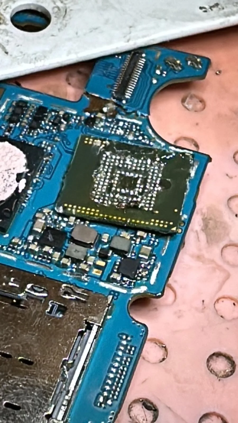 Placă de bază de telefon, albastră, în timpul unei reparații de micro-soldering