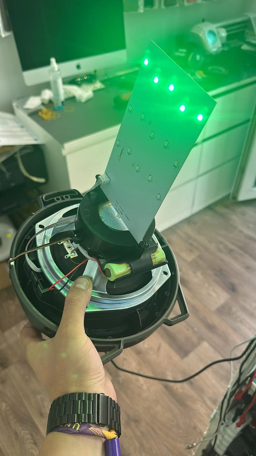 Display de telefon ridicat de pe o mașină de separare, sub o lumină verde UV