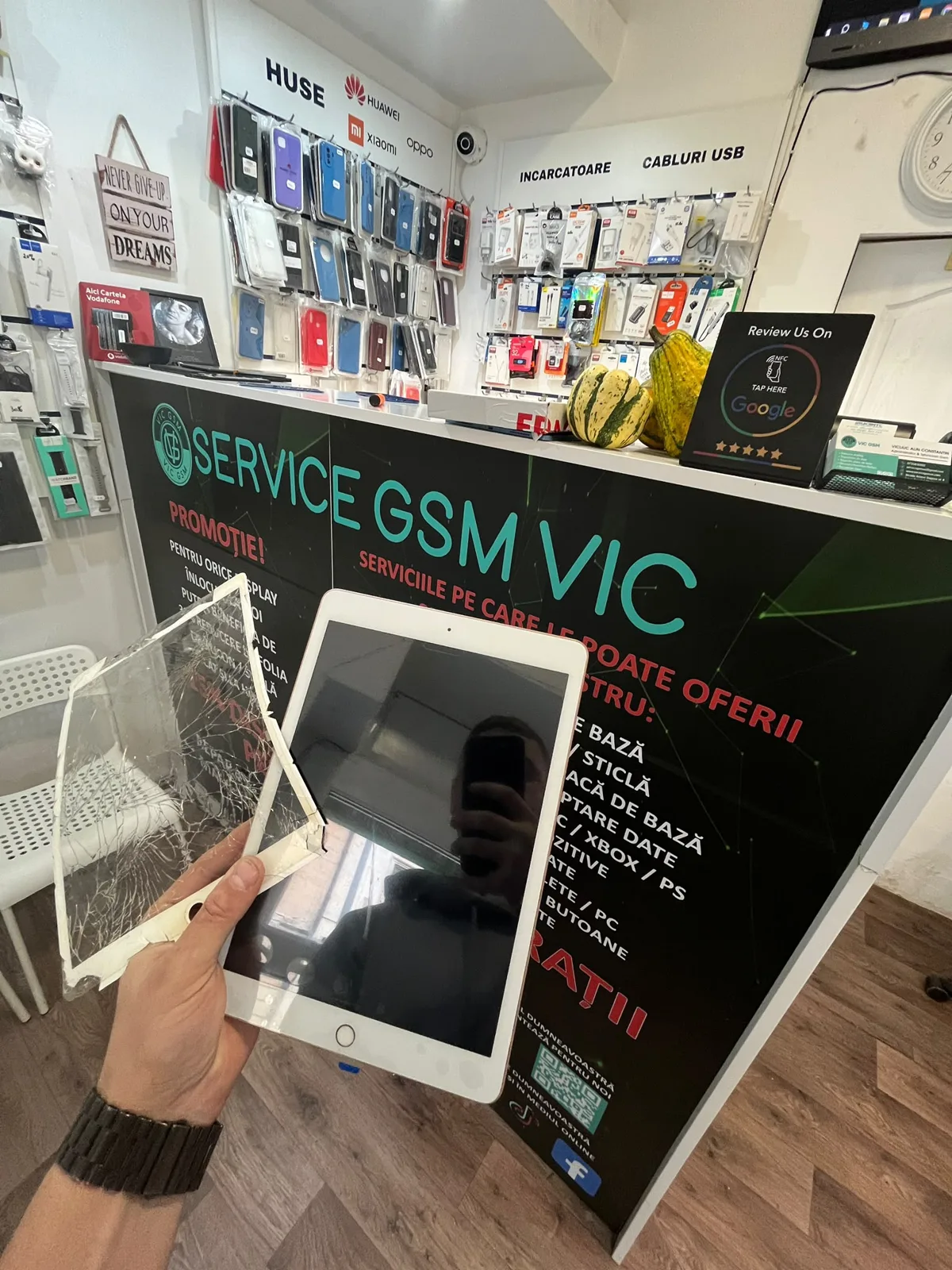 iPad cu sticla înlocuită, ținut lângă sticla veche spartă